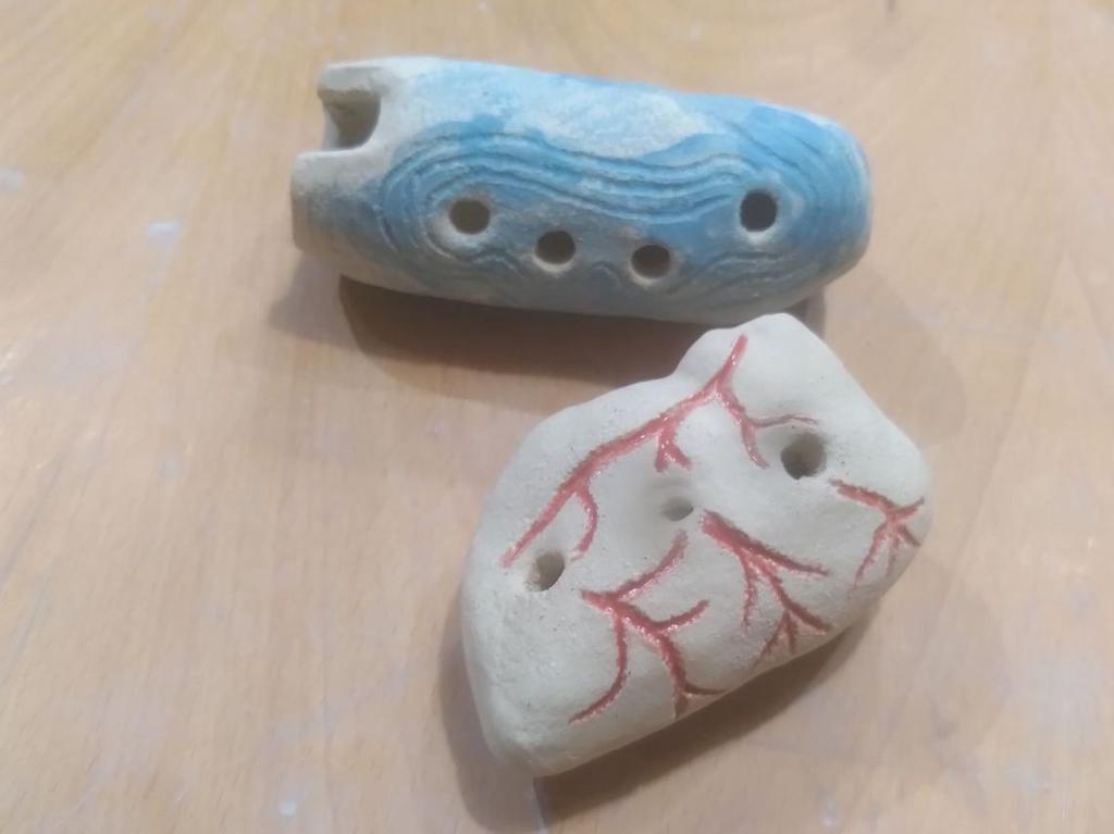 Photo from the blowing holes.
The somewhat tubular works as a quena to produce sound, the heart-shaped one is more of a typical ocarina.