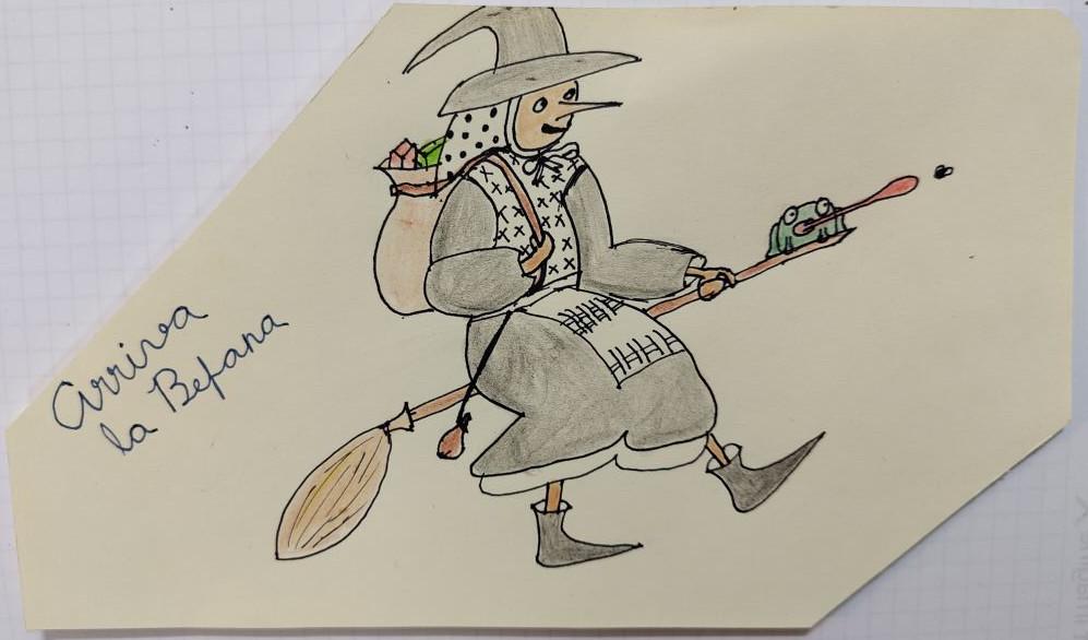 Una bruixeta molt simpàtica volant en una escombra.
Porta a l'esquena una bossa plena de paquetets de colors (regals), està vestida principalment de gris, amb peces blanques amb patrons negres.
A la punta de l'esquena porta una granota, que està a punt de menjar-se una mosca.